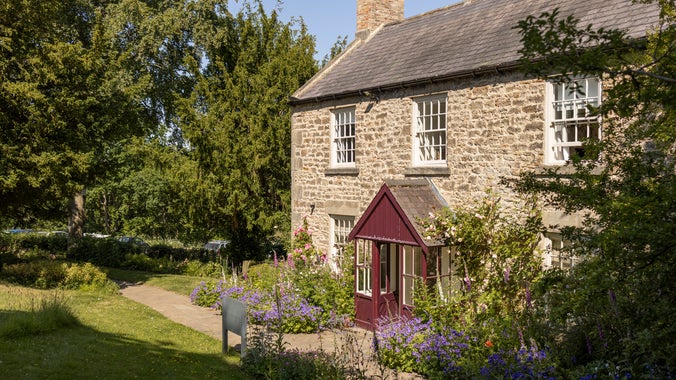 Cherryburn's farmhouse with spring flowers in front